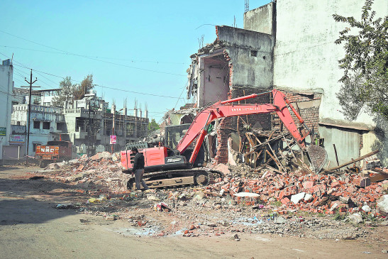 Pucca houses broken down with bulldozers, obstructing road construction